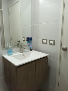 La salle de bains est pourvue d'un lavabo et d'un miroir. dans l'établissement Grato y nuevo departamento, à Quilpué