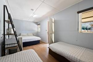 a bedroom with two beds and a ladder at Bright Cabin Park in Bright