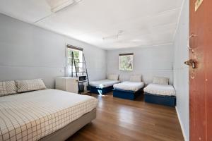 a bedroom with two beds and two chairs at Bright Cabin Park in Bright