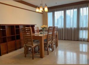 ein Esszimmer mit einem Holztisch und Stühlen in der Unterkunft Park Royale Apartments, Senayan, Jakarta in Jakarta