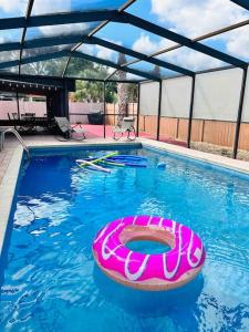 einen Pool mit einem rosa Floß im Wasser in der Unterkunft Vintage Family Scape + heated pool&discount in Tampa