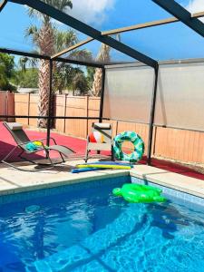 ein Schwimmbad mit einem grünen Objekt im Wasser in der Unterkunft Vintage Family Scape + heated pool&discount in Tampa