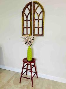 eine Vase mit Blumen auf einem Stuhl unter einem Spiegel in der Unterkunft Vintage Family Scape + heated pool&discount in Tampa