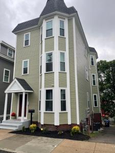 a large yellow house with a gambrel roof at Boston Luxury 3 bedroom Private Condo in Boston