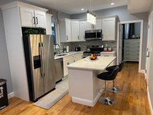 a kitchen with white cabinets and a stainless steel refrigerator at Boston Luxury 3 bedroom Private Condo in Boston