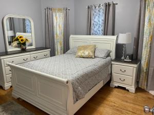 a bedroom with a white bed with two dressers and a mirror at Boston Luxury 3 bedroom Private Condo in Boston
