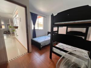 a room with two bunk beds and a fan at Epifania Hostel in Cali