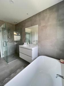 a bathroom with a tub and a sink and a shower at Queenstown Mountain Getaway in Queenstown