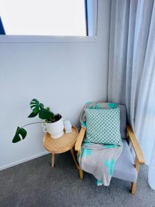 a room with a chair and a plant on a table at Queenstown Mountain Getaway in Queenstown +46 photos