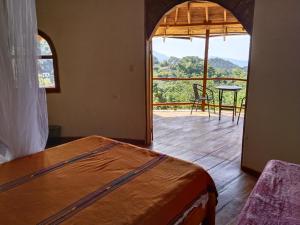 a bedroom with a bed and a balcony with a table at Casa Magica in Minca