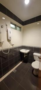 a bathroom with a toilet and a sink at Tas Sakura Budget Hotel in Kampong Baharu