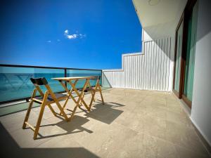 a table and chairs on a balcony with the ocean at 1 Corcega Beachfront Suites in Rincon