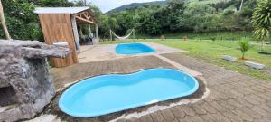 une piscine en plastique bleue dans une cour avec une aire de jeux dans l'établissement Chácara Moreira's, à Barra do Turvo