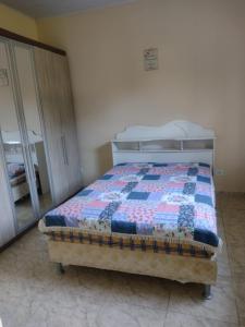 - un lit avec une couette dans une chambre dans l'établissement Chácara Moreira's, à Barra do Turvo