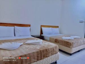 2 Betten nebeneinander in einem Zimmer in der Unterkunft Tunas Cottage 2 in Kuah