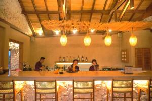 a restaurant with a bar with people sitting at it at Villa Suerte in Jepara