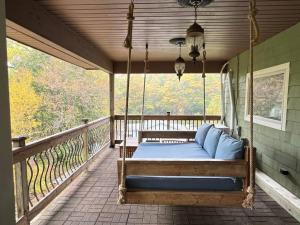 a porch swing with blue pillows on a porch at Emerald Shores in Coloma