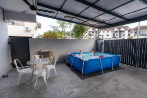 a blue ping pong table on a patio with chairs at 10Px 5BR V Jaccuzi Spa n KTV n Kids Pool n Pool Table Near USM n Lam Wah Ee Hospital in Gelugor