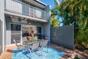 a patio with a table and chairs in front of a house at Sunset Waters 1 by HamoRent on Hamilton Island in Hamilton Island