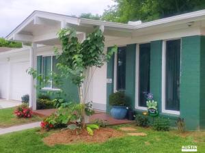 una casa verde con un árbol delante en Austin Greenhouse Rentals, en Austin