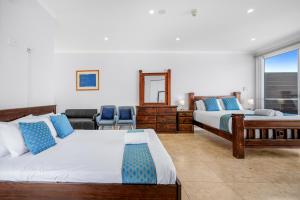 1 dormitorio con 2 camas y ventana en Lakes Resort, en Toukley