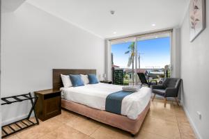 Lakes Resort Toukley في توكلي: غرفة نوم بها سرير ونافذة كبيرة +256 صورة