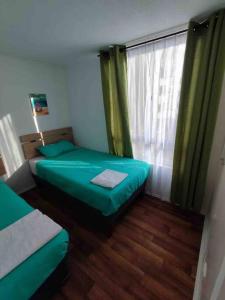 um pequeno quarto com 2 camas e uma janela em Departamento nuevo sector sur entregado el 2022 em Antofagasta