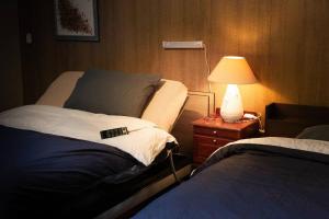 Postel nebo postele na pokoji v ubytování 伊豆高原 桜並木通りに面したコテージJiro's