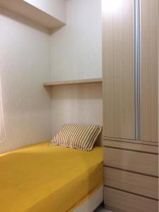 TjikokolにあるApartement Ayodhya 2BR By Vinsの小さなベッドルーム(黄色のベッド1台、キャビネット付)