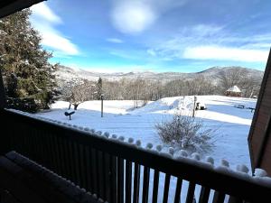 a view of a snow covered yard from a balcony at White Mountains Getaway with amazing views! in Bartlett