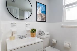 a white bathroom with a mirror and a toilet at Be A Nomad Beachside Apartments in Jacksonville Beach
