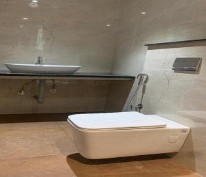een badkamer met een wit toilet en een wastafel bij G R B Hotels Aishwarya Grand in Pondicherry