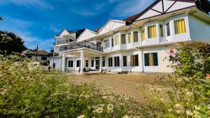 Cette grande maison blanche possède de nombreuses fenêtres. dans l'établissement Eden Hill Hotel, à Nuwara Eliya