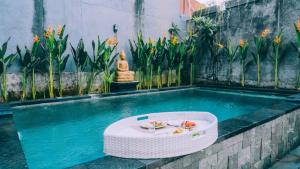 a pool with a table with a bowl of fruit in it at Budha Manis Villa in Kerobokan