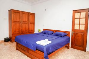 1 dormitorio con 1 cama con edredón azul en The Anam Hostel, en Colombo