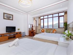 um quarto com 2 camas e uma televisão de ecrã plano em KHÁCH SẠN SƠN THỊNH 23D THÙY VÂN em Vung Tau