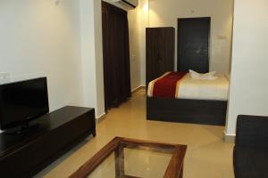een hotelkamer met een bed en een televisie bij G R B Hotels Aishwarya Grand in Pondicherry