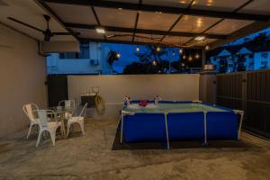 eine Tischtennisplatte in einer Garage mit einem Tisch und Stühlen in der Unterkunft TOWN 13Px 5R4B V KIDS POOL & KTV & JACCUZI SPA & POOL TABLE NEAR USM & LAM WAH EE HOSPITAL & HAN CHIANG HIGH SCHOOL in Gelugor