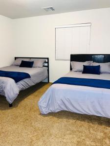 um quarto com 2 camas e almofadas azuis em 3BR King Suite/Near Strip/Wi-Fi em Las Vegas