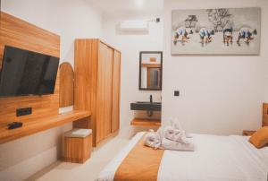 a bedroom with a bed and a flat screen tv at Budha Manis Villa in Kerobokan +25 photos