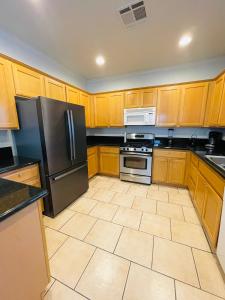 uma cozinha com armários de madeira e electrodomésticos de aço inoxidável em 3BR King Suite/Near Strip/Wi-Fi em Las Vegas