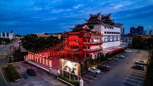 un grand bâtiment avec des lumières rouges en face dans l'établissement Heng Ann Guest House, à Malacca