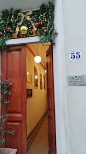 um corredor com uma porta com um jardim de Natal por cima em Tre Gigli Firenze BB, 5 minutes from station, via Palazzuolo 55 em Florença