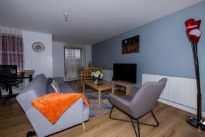 un salon avec un canapé, des fauteuils et une télévision dans l'établissement Pristine Relocation Pamers Green, à Londres