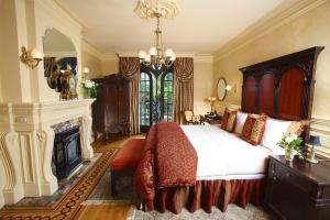 a bedroom with a large bed and a fireplace at Ledson Hotel & Zina Lounge in Sonoma