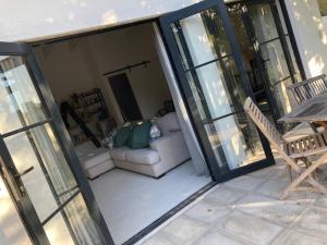a patio with a couch and a table and glass doors at Morningside Studio apartment, load shedding proof in Cape Town