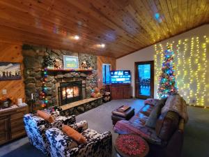 een woonkamer met een open haard en een kerstboom bij Four Seasons Getaway-with Hot Tub, Next to Village and Hiking Trailhead in Big Bear Lake