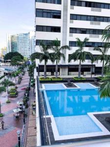 vistas a un edificio con piscina y palmeras en Suite de lujo en la ciudad Puerto Santa Ana, en Guayaquil