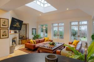a living room with leather furniture and a skylight at Stunning 6-bedroom countryside home in Reading