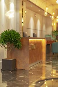 a reception desk in a lobby with a potted plant at THE ELITE HOTEL in Da Lat